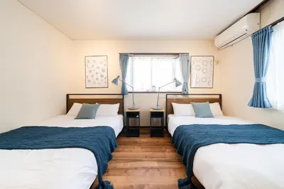 two twin beds in a room with a window at HOTEL AndPlace ShinOkubo in Tokyo