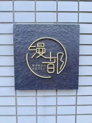 a sign for a mano hotel on a tile wall at Mando Hotel 101 ,direct to Ueno,Asakusa in Tokyo