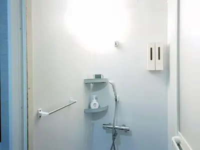 a bathroom with a shower in the corner of a room at Mando Hotel 101 ,direct to Ueno,Asakusa in Tokyo