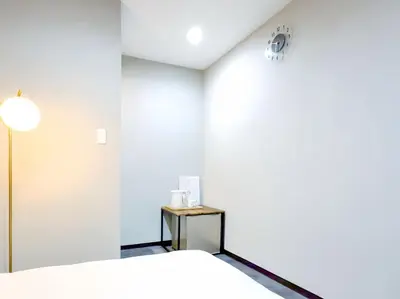 a white room with a bed and a table at Mando Hotel 101 ,direct to Ueno,Asakusa in Tokyo