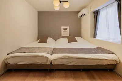 a bedroom with a large bed with a window at Suzume sky house in Tokyo