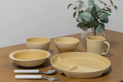 a table with four bowls and a vase with a plant at Suzume sky house in Tokyo