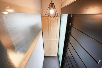 a hallway with a black garage door and a light fixture at R-Styles \u6e0b\u8c37 in Tokyo