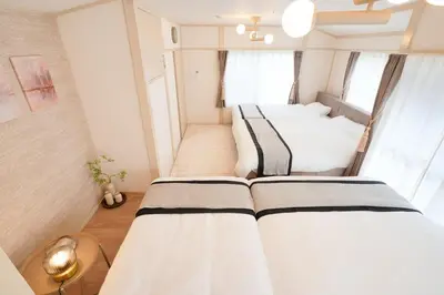 a bedroom with three beds in a room at R-Styles \u6e0b\u8c37 in Tokyo