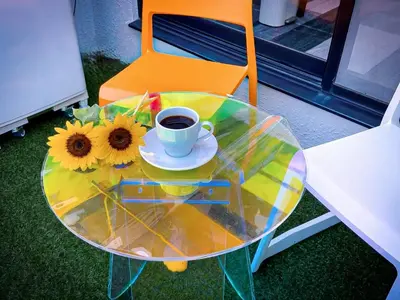 a glass table with a cup of coffee and sunflowers on it at Mando Hotel 201 ,direct to Ueno,Asakusa in Tokyo