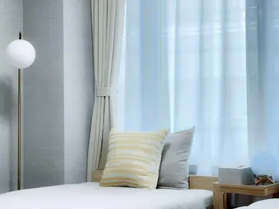 a bed with a pillow in front of a window at Mando Hotel 201 ,direct to Ueno,Asakusa in Tokyo