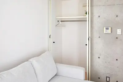 a living room with a white couch and a closet at 3-min walk to bus stop, direct to Shibuya Shinjuku in Tokyo