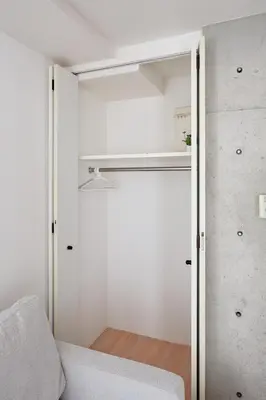 a small room with a closet with a white couch at 3-min walk to bus stop, direct to Shibuya Shinjuku in Tokyo