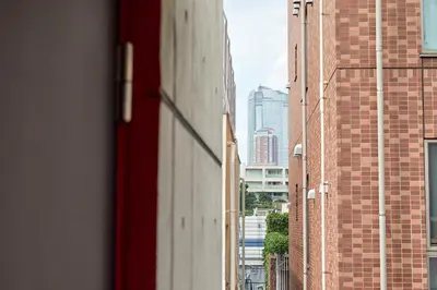 a view of an alley between two brick buildings at 3-min walk to bus stop, direct to Shibuya Shinjuku in Tokyo