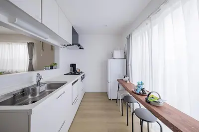 a kitchen with white cabinets and a wooden counter top at Tokyo Kanamachi Inn in Tokyo