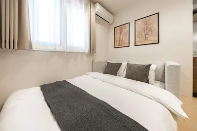 a bedroom with a white bed and a window at \u4e09\u8ed2\u8336\u5c4bCasa Blanky in Tokyo