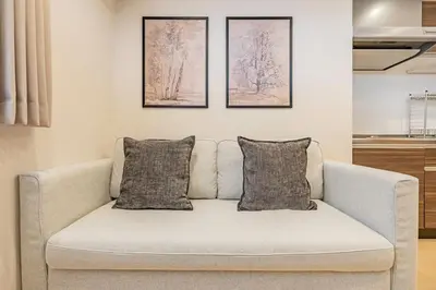 a couch in a living room with three pictures on the wall at \u4e09\u8ed2\u8336\u5c4bCasa Blanky in Tokyo