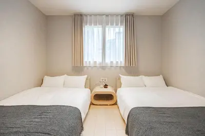 two beds in a small room with a window at \u4e09\u8ed2\u8336\u5c4bCasa Blanky in Tokyo