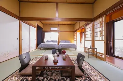 a bedroom with two beds and a table and chairs at \u7985-zen-Tokyo Itabashi in Tokyo