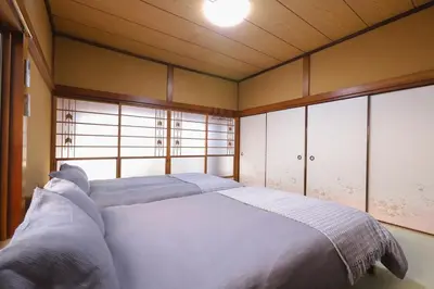 a bedroom with a bed in a room with windows at \u7985-zen-Tokyo Itabashi in Tokyo