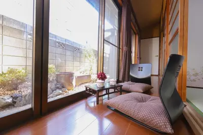 a living room with two chairs and a large window at \u7985-zen-Tokyo Itabashi in Tokyo