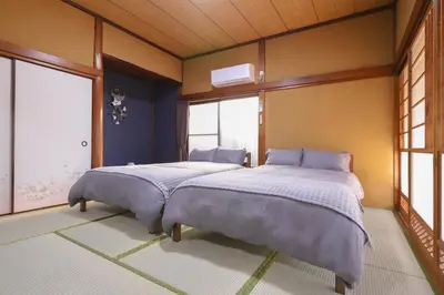 two beds in a room with two windows at \u7985-zen-Tokyo Itabashi in Tokyo