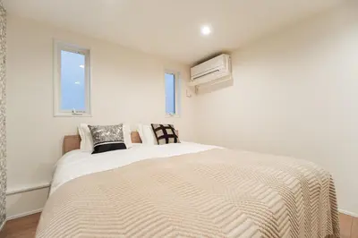a white bedroom with a bed and two windows at \u76ee\u767d\u522b\u5885 \u5168\u65b03\u5c42\u697c\u72ec\u680b\u522b\u5885\u5bb6\u7684\u611f\u89c9 3\u5367\u5ba4Brand new 3-story detached villa with a homey feel 3 rooms \u8fd1\u5546\u5708 \u8bbe\u5907\u9f50\u5168 \u76f4\u8fbe\u65b0\u5bbf \u94f6\u5ea7 \u6d89\u8c37 \u4e0a\u91ce \u8868\u53c2\u9053 \u54c1\u5ddd in Tokyo