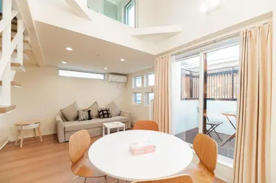 a living room with a table and a couch at \u76ee\u767d\u522b\u5885 \u5168\u65b03\u5c42\u697c\u72ec\u680b\u522b\u5885\u5bb6\u7684\u611f\u89c9 3\u5367\u5ba4Brand new 3-story detached villa with a homey feel 3 rooms \u8fd1\u5546\u5708 \u8bbe\u5907\u9f50\u5168 \u76f4\u8fbe\u65b0\u5bbf \u94f6\u5ea7 \u6d89\u8c37 \u4e0a\u91ce \u8868\u53c2\u9053 \u54c1\u5ddd in Tokyo