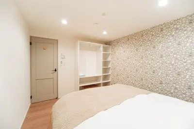 a bedroom with a white bed and a wall at \u76ee\u767d\u522b\u5885 \u5168\u65b03\u5c42\u697c\u72ec\u680b\u522b\u5885\u5bb6\u7684\u611f\u89c9 3\u5367\u5ba4Brand new 3-story detached villa with a homey feel 3 rooms \u8fd1\u5546\u5708 \u8bbe\u5907\u9f50\u5168 \u76f4\u8fbe\u65b0\u5bbf \u94f6\u5ea7 \u6d89\u8c37 \u4e0a\u91ce \u8868\u53c2\u9053 \u54c1\u5ddd in Tokyo
