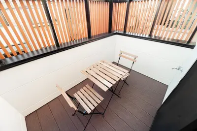 a bench and two chairs sitting on a balcony at \u76ee\u767d\u522b\u5885 \u5168\u65b03\u5c42\u697c\u72ec\u680b\u522b\u5885\u5bb6\u7684\u611f\u89c9 3\u5367\u5ba4Brand new 3-story detached villa with a homey feel 3 rooms \u8fd1\u5546\u5708 \u8bbe\u5907\u9f50\u5168 \u76f4\u8fbe\u65b0\u5bbf \u94f6\u5ea7 \u6d89\u8c37 \u4e0a\u91ce \u8868\u53c2\u9053 \u54c1\u5ddd in Tokyo
