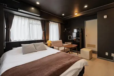 a bedroom with a large bed and a chair at M's GARDEN KIYOSUMI in Tokyo