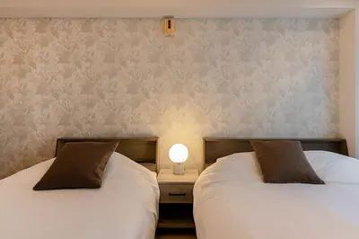 two beds sitting next to each other in a room at M's GARDEN KIYOSUMI in Tokyo