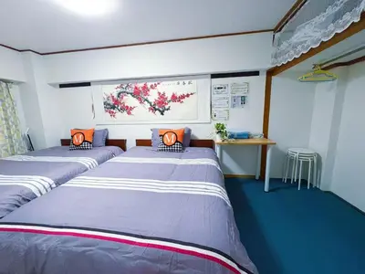 two twin beds in a room with blue carpet at Kabuki house in Tokyo