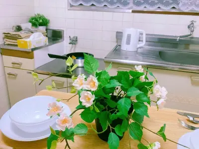a vase of flowers on a table in a kitchen at Kabuki house in Tokyo