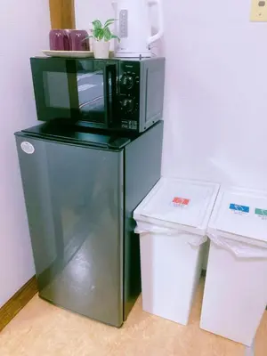a microwave sitting on top of a refrigerator at Kabuki house in Tokyo