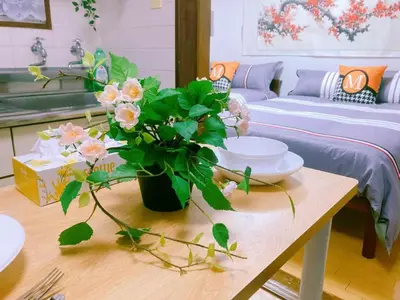 a living room with a table with a vase of flowers at Kabuki house in Tokyo