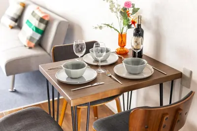 a wooden table with two plates and wine glasses at Happy House Residence in Tokyo