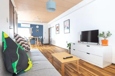 a living room with a couch and a tv at Happy House Residence in Tokyo
