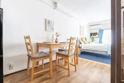 a dining room with a table and chairs and a bedroom at Happy House Residence in Tokyo