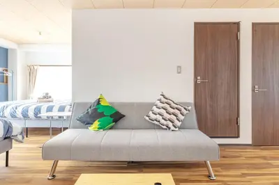 a living room with a couch and a bed at Happy House Residence in Tokyo