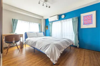 a bedroom with blue walls and a bed and a desk at Happy House Residence in Tokyo