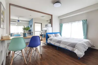 a bedroom with a bed and a desk and two chairs at Happy House Residence in Tokyo