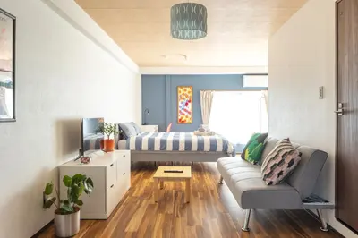 a living room with a couch and a bed at Happy House Residence in Tokyo
