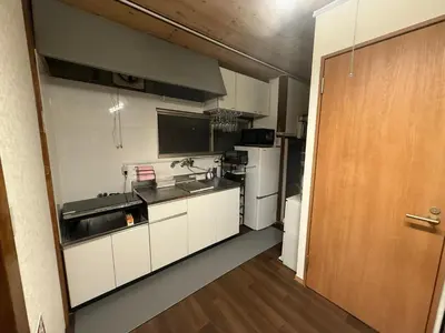 a kitchen with white cabinets and a wooden door at \u307b\u307e\u308c\u53e4\u6c11\u5bb6\u4e00\u68df\u8cb8\u3057\u65b0\u5c0f\u5ca9\u99c5\u5f92\u6b6917\u5206 in Tokyo
