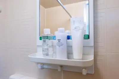 a shelf in a bathroom with many bottles of toothpaste at Kamimachi Stay102 in Tokyo