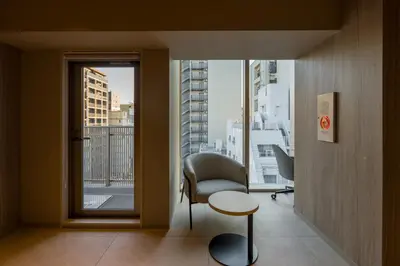 a room with a chair and a table and a window at Sumu Ueno East in Tokyo