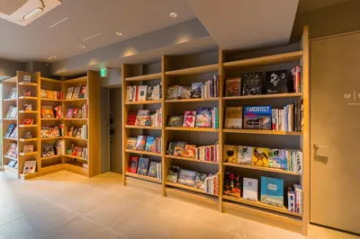 a library with wooden shelves filled with books at Sumu Ueno East in Tokyo