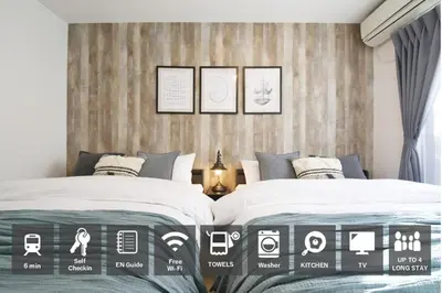 a bedroom with two beds and a wooden wall at AirHOMETOKYO EBISU 202 in Tokyo