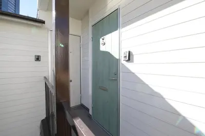 a green door on the side of a house at AirHOMETOKYO EBISU 202 in Tokyo