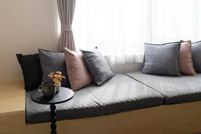 a couch with pillows and a table in front of a window at Sora Den-en Stay in Tokyo