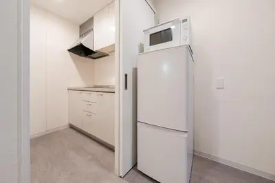 a white refrigerator in a kitchen with a microwave at Sora Den-en Stay in Tokyo