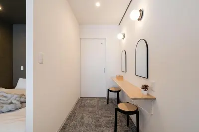 a room with a bed and a desk with two stools at Sora Den-en Stay in Tokyo