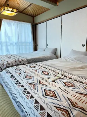 two beds in a bedroom with a quilt on it at \u65b0\u5bbf\u795e\u697d\u5742\u8fd1\u304f\u5bff\u53f8\u5e973 in Tokyo