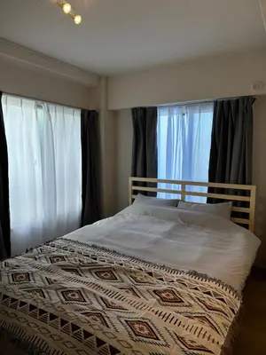 a bed in a bedroom with two windows at \u65b0\u5bbf\u795e\u697d\u5742\u8fd1\u304f\u5bff\u53f8\u5e973 in Tokyo