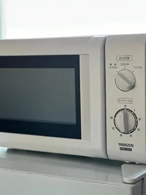 a white microwave oven sitting on top of a counter at \u65b0\u5bbf\u795e\u697d\u5742\u8fd1\u304f\u5bff\u53f8\u5e973 in Tokyo